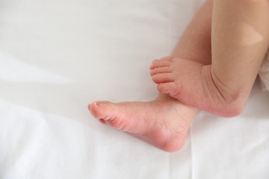 Photo of Cute newborn baby lying on bed, top view. Space for text