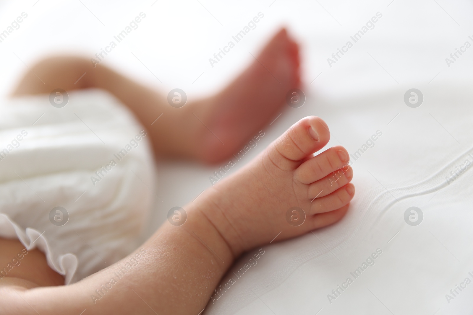 Cute newborn baby lying on bed indoors, closeup Photo of Cute newborn baby lying on bed indoors, closeup