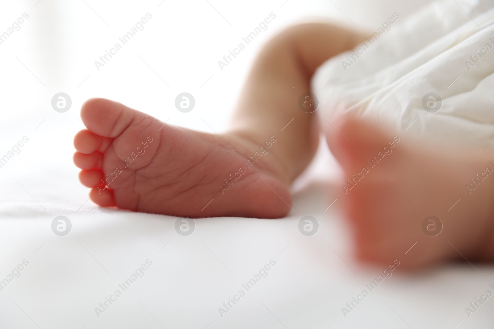 Cute newborn baby lying on bed indoors, closeup Photo of Cute newborn baby lying on bed indoors, closeup