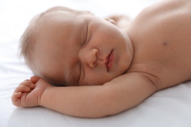 Photo of Cute newborn baby sleeping on bed indoors, closeup