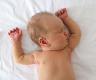 Photo of Cute newborn baby sleeping on bed, top view