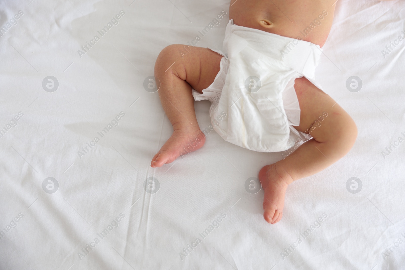 Cute newborn baby lying on bed, top view. Space for text Photo of Cute newborn baby lying on bed, top view. Space for text