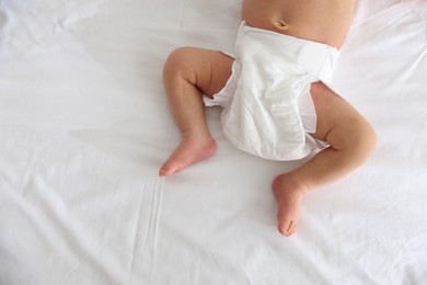 Photo of Cute newborn baby lying on bed, top view. Space for text