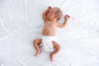 Photo of Cute newborn baby sleeping on bed, top view