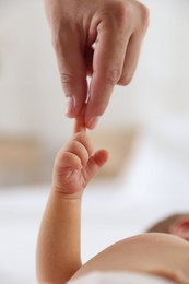 Photo of Mother with her cute newborn baby on bed indoors, closeup