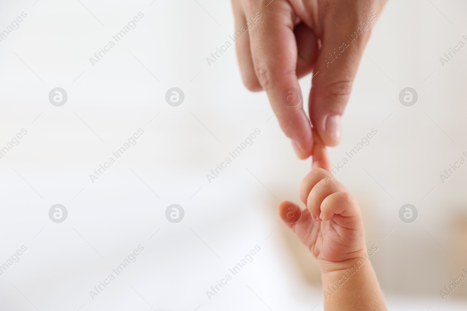 Mother with her cute newborn baby on bed indoors, closeup Photo of Mother with her cute newborn baby on bed indoors, closeup