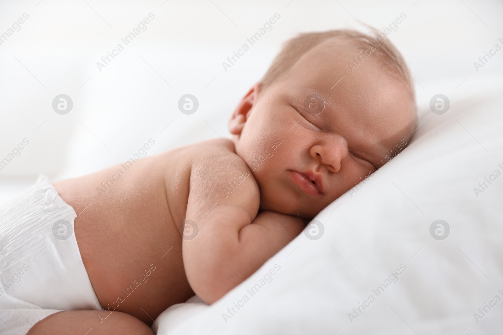 Cute newborn baby sleeping on pillow indoors Photo of Cute newborn baby sleeping on pillow indoors