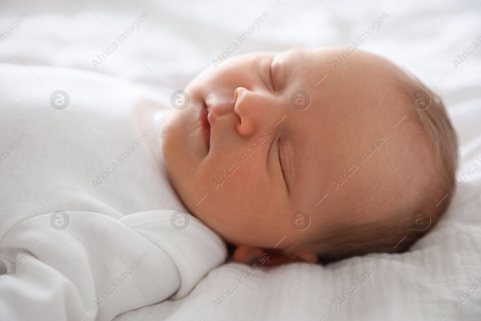 Cute newborn baby sleeping on bed indoors Photo of Cute newborn baby sleeping on bed indoors