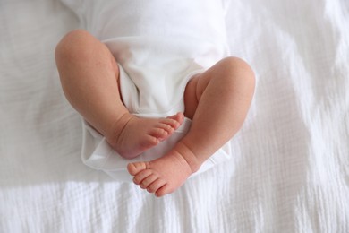 Photo of Cute newborn baby lying on bed, top view