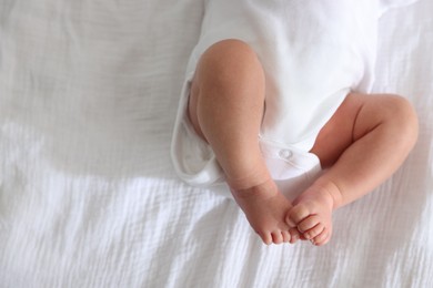 Photo of Cute newborn baby lying on bed, top view. Space for text