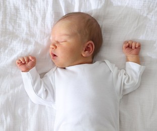Photo of Cute newborn baby sleeping on bed, top view