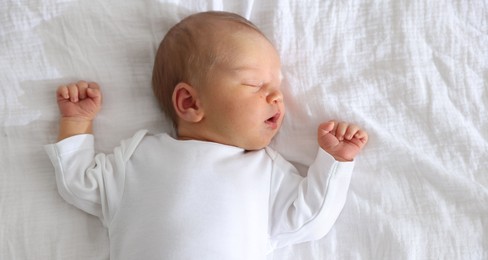 Photo of Cute newborn baby sleeping on bed, top view