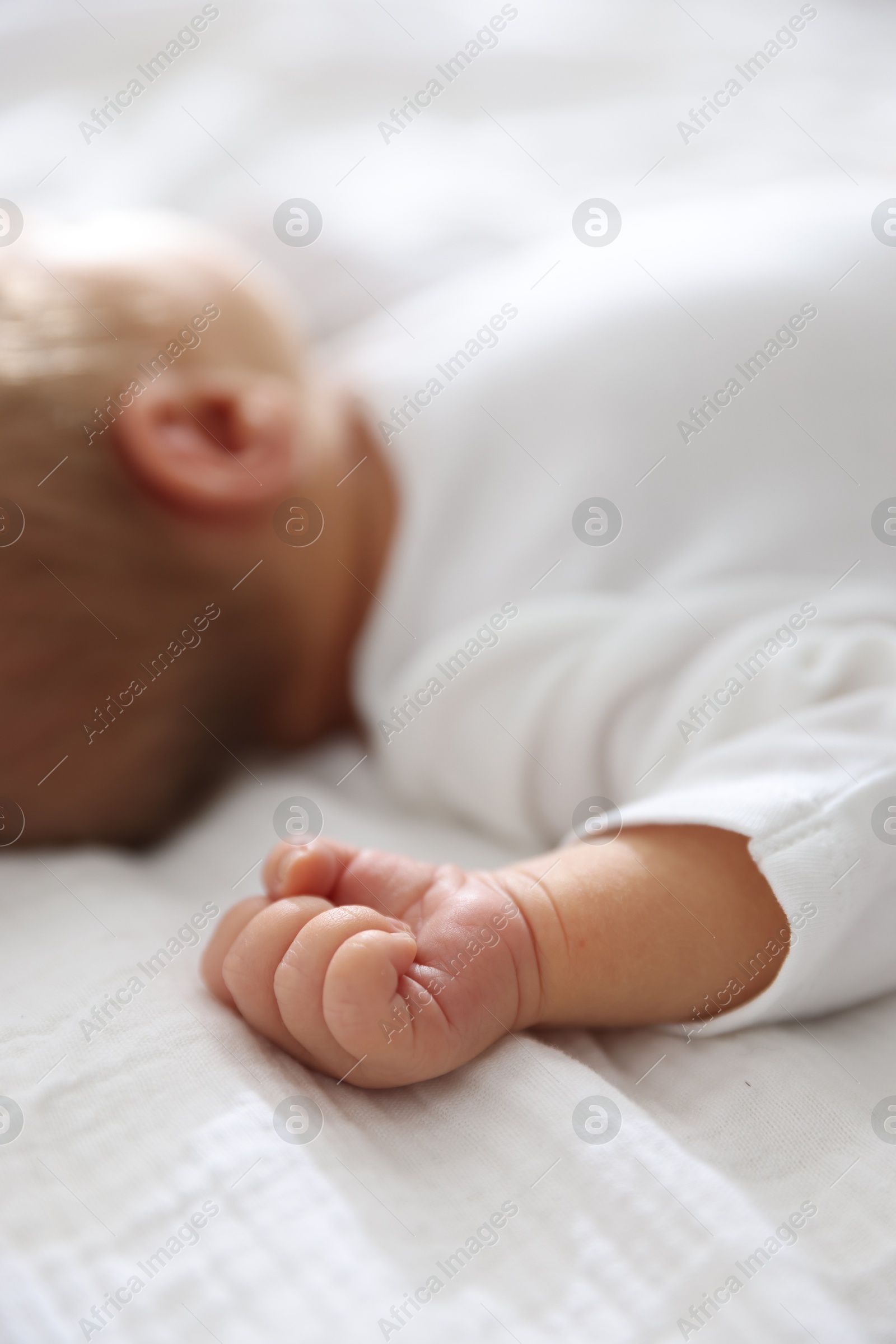 Cute newborn baby lying on bed indoors, closeup Photo of Cute newborn baby lying on bed indoors, closeup