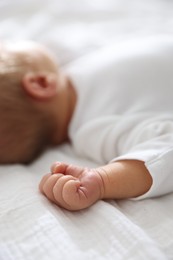 Photo of Cute newborn baby lying on bed indoors, closeup