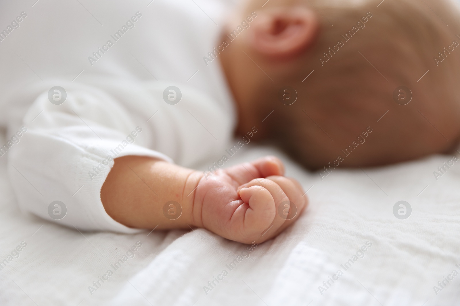 Cute newborn baby lying on bed indoors, closeup Photo of Cute newborn baby lying on bed indoors, closeup