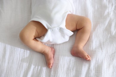 Photo of Cute newborn baby lying on bed indoors, top view
