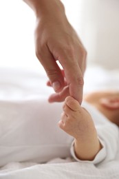 Photo of Mother with her cute newborn baby on bed indoors, closeup