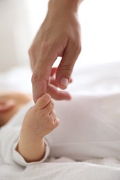 Photo of Mother with her cute newborn baby on bed indoors, closeup