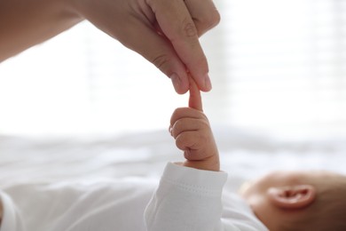 Photo of Mother with her cute newborn baby on bed indoors, closeup