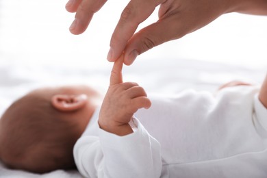 Photo of Mother with her cute newborn baby on bed indoors, closeup