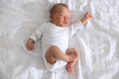 Photo of Cute newborn baby sleeping on bed, top view