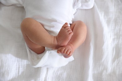 Photo of Cute newborn baby lying on bed, top view