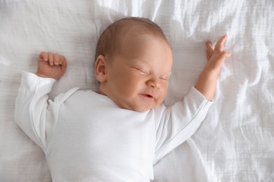 Photo of Cute newborn baby sleeping on bed, top view