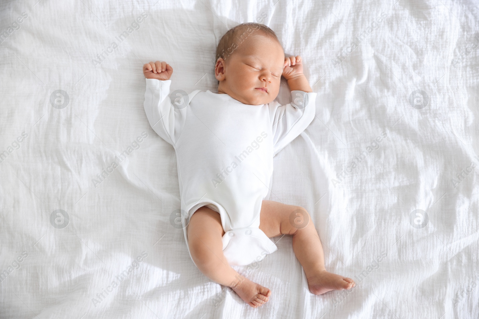 Photo of Cute newborn baby sleeping on bed, top view