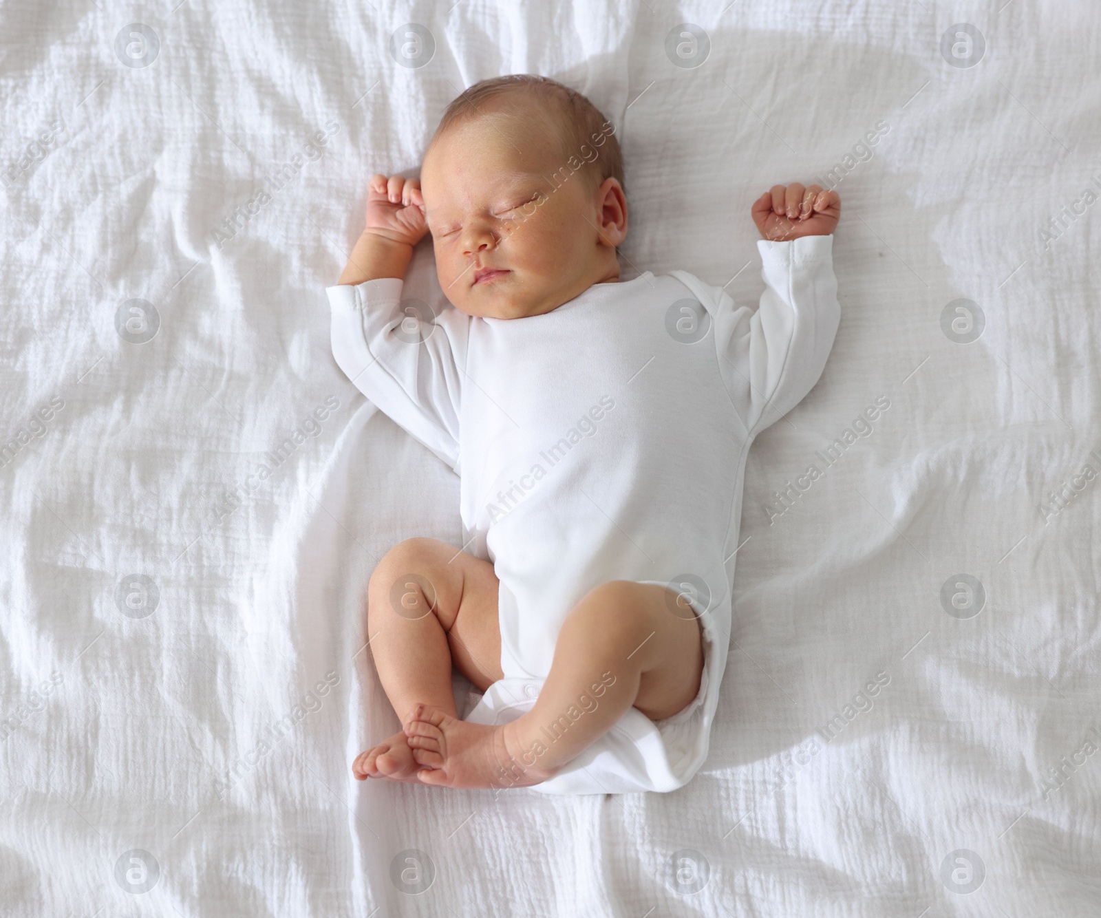 Photo of Cute newborn baby sleeping on bed, top view