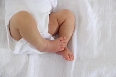 Photo of Cute newborn baby lying on bed, top view. Space for text