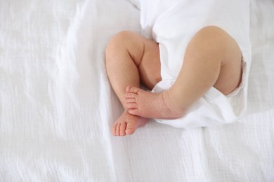 Photo of Cute newborn baby lying on bed, top view. Space for text