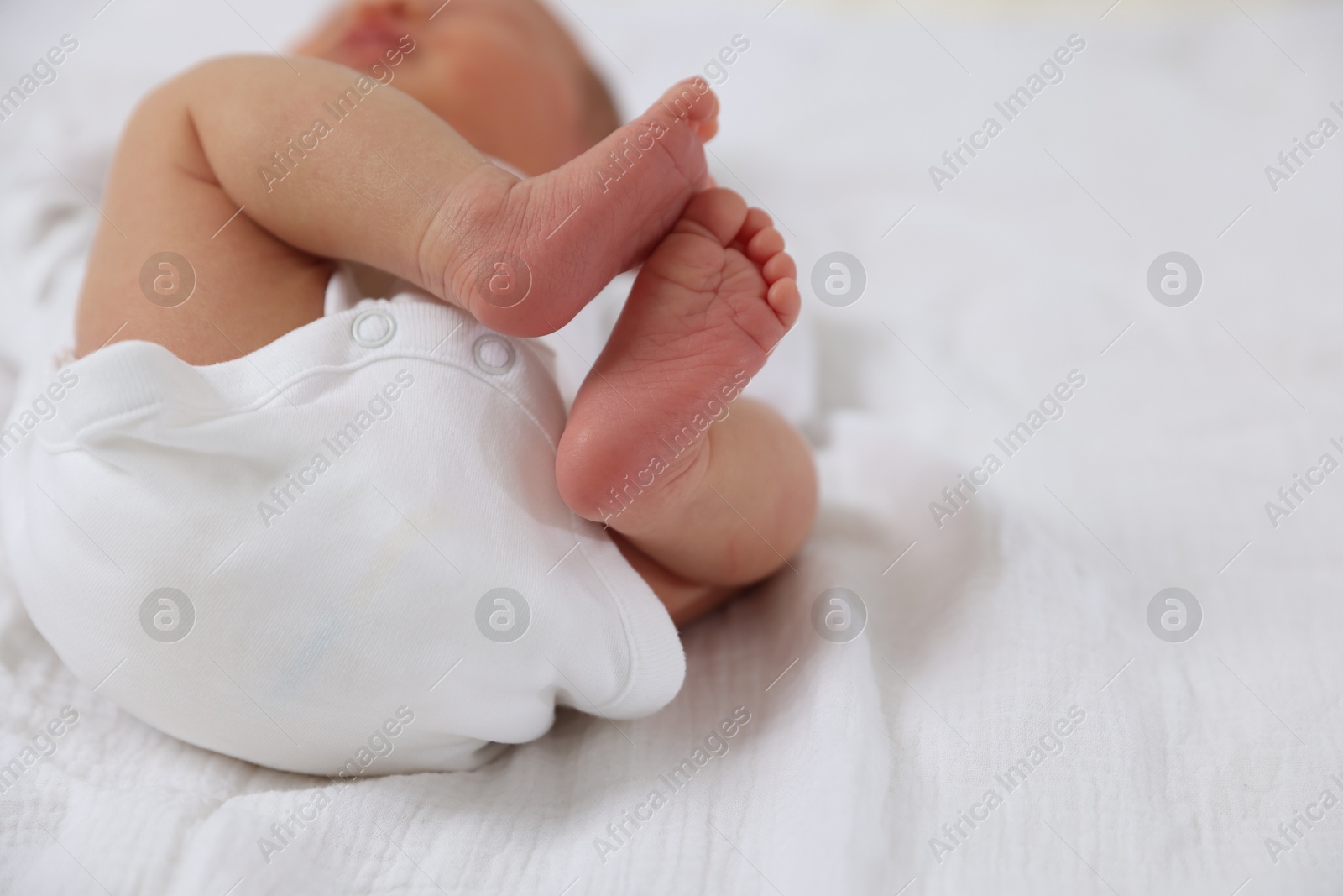 Cute newborn baby lying on bed, closeup. Space for text Photo of Cute newborn baby lying on bed, closeup. Space for text