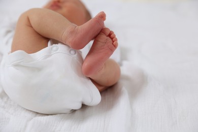 Photo of Cute newborn baby lying on bed, closeup. Space for text