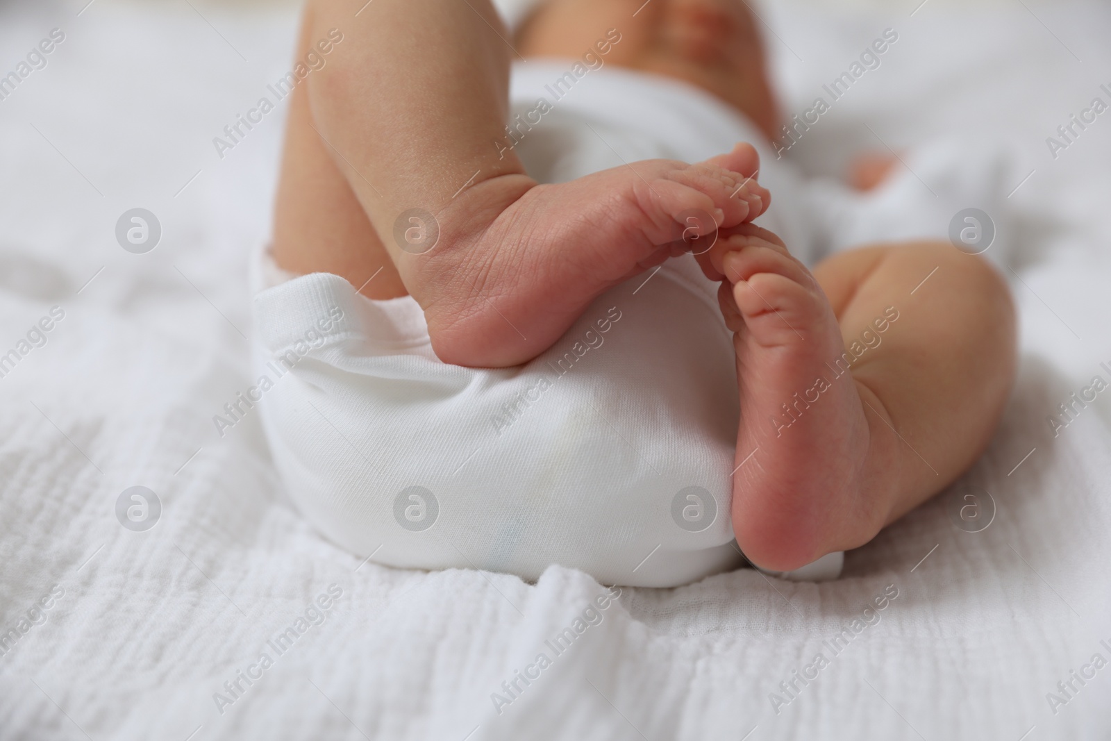 Cute newborn baby lying on bed, closeup Photo of Cute newborn baby lying on bed, closeup