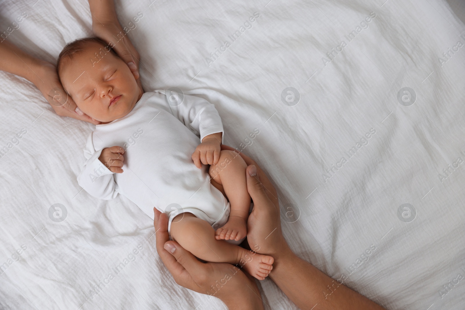 Parents with their cute newborn baby on bed, top view. Space for text Photo of Parents with their cute newborn baby on bed, top view. Space for text
