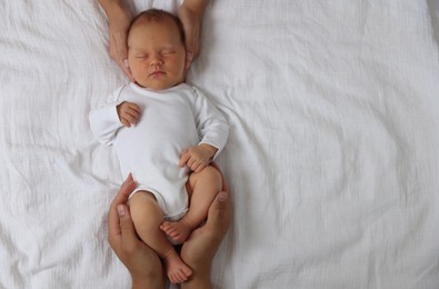 Photo of Parents with their cute newborn baby on bed, top view. Space for text