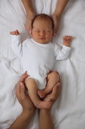 Photo of Parents with their cute newborn baby on bed, top view