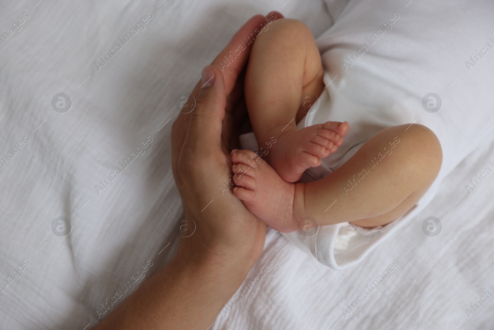 Father with his cute newborn baby on bed, top view Photo of Father with his cute newborn baby on bed, top view