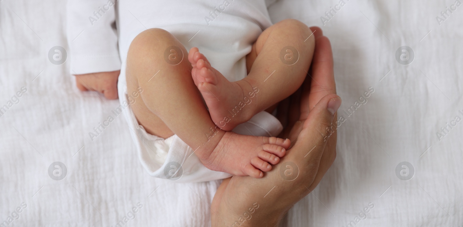 Father with his cute newborn baby on bed, top view Photo of Father with his cute newborn baby on bed, top view