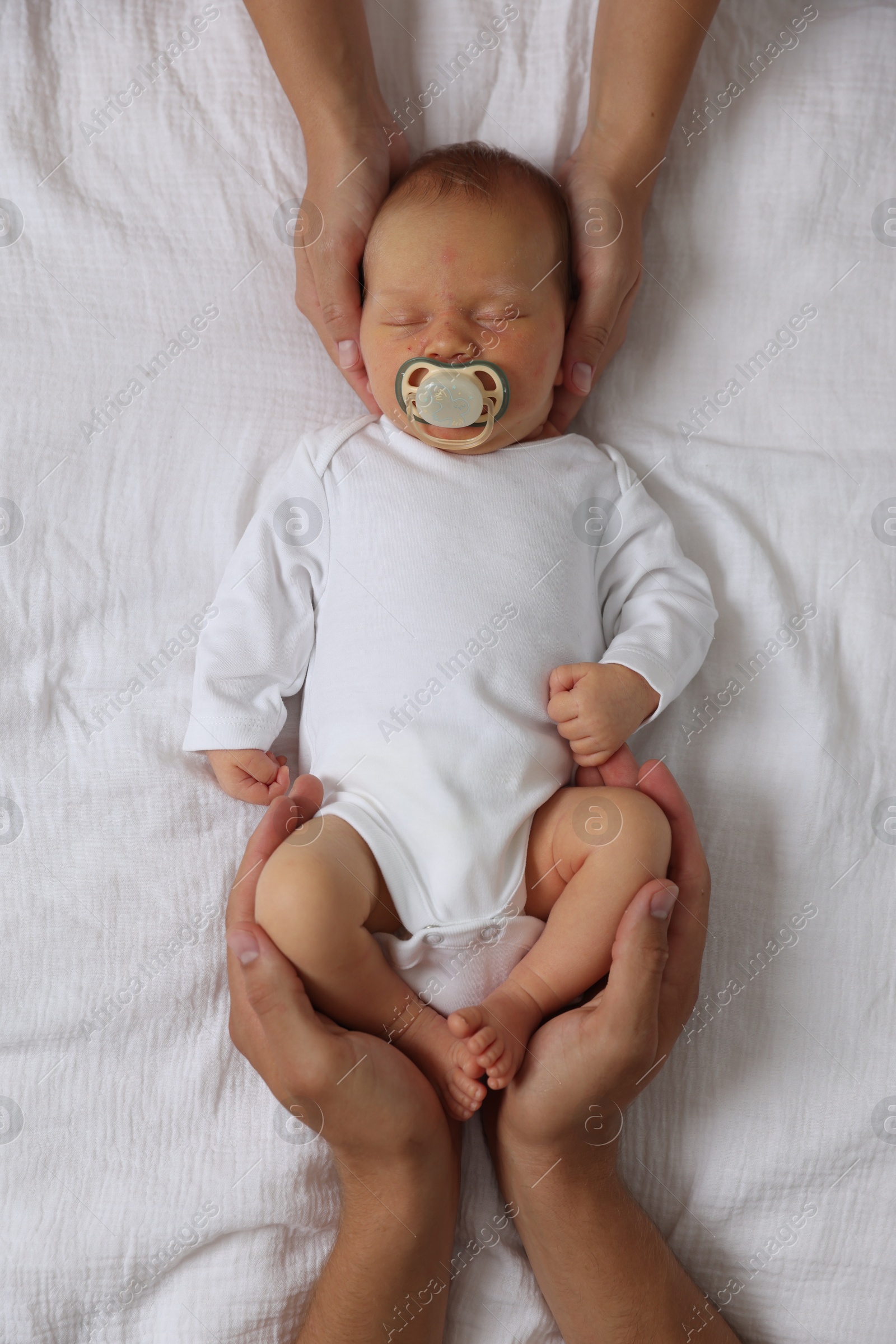 Parents with their cute newborn baby on bed, top view Photo of Parents with their cute newborn baby on bed, top view