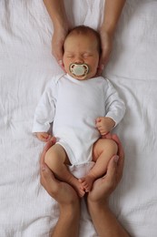 Photo of Parents with their cute newborn baby on bed, top view