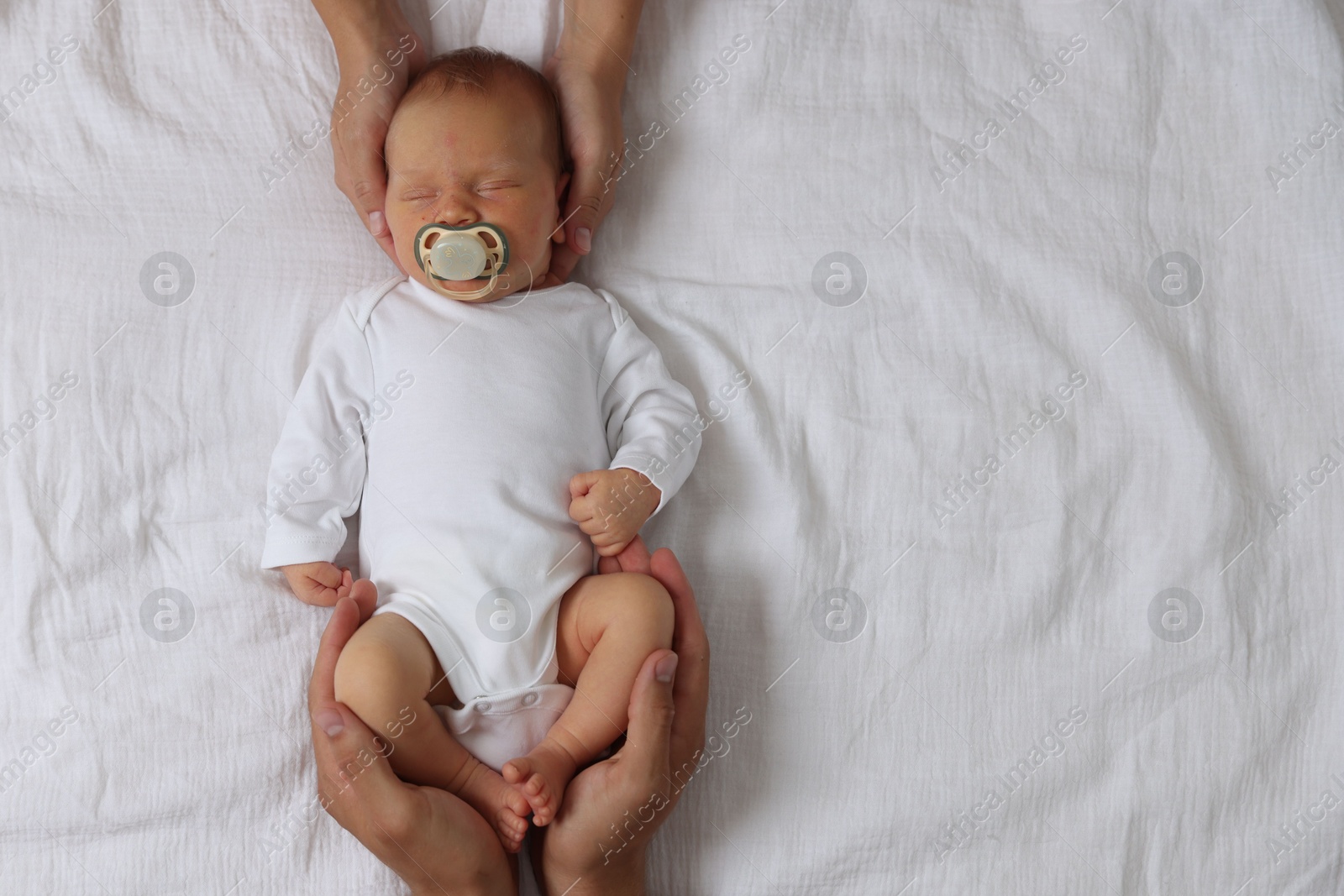 Parents with their cute newborn baby on bed, top view. Space for text Photo of Parents with their cute newborn baby on bed, top view. Space for text