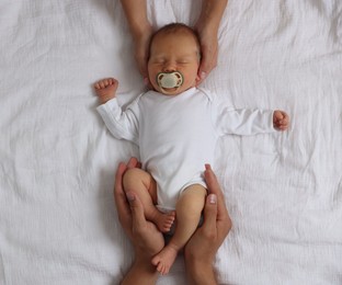 Photo of Parents with their cute newborn baby on bed, top view