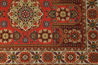 Photo of Soft red carpet with pattern as background, top view. Used stuff