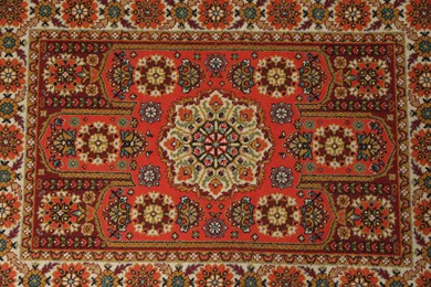 Photo of Soft red carpet with pattern as background, top view. Used stuff