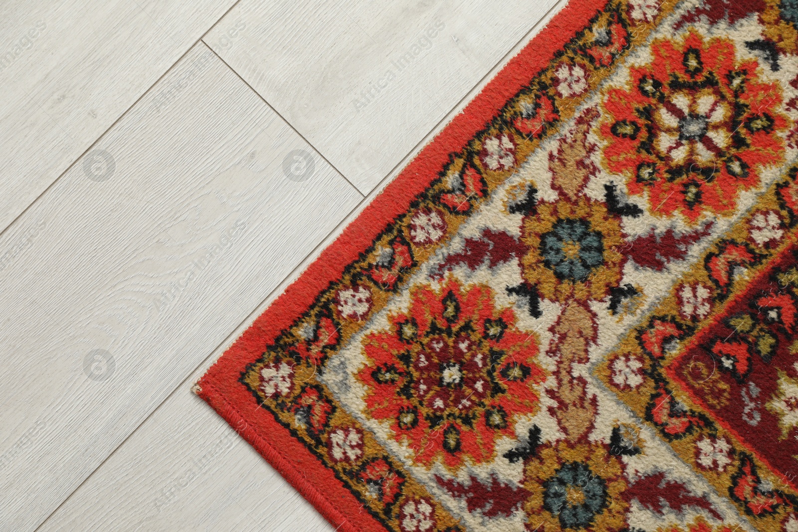 Soft red carpet with pattern on light wooden floor, top view with space for text. Used stuff Photo of Soft red carpet with pattern on light wooden floor, top view with space for text. Used stuff