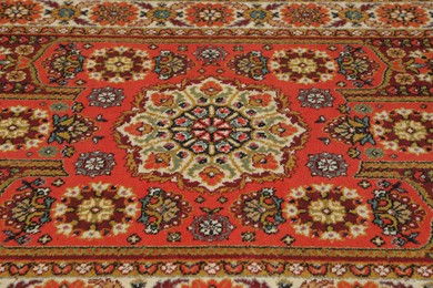 Photo of Soft red carpet with pattern, closeup. Used stuff