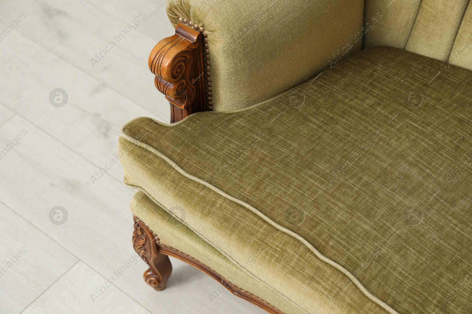 Soft sofa on light wooden floor, closeup. Used stuff Photo of Soft sofa on light wooden floor, closeup. Used stuff