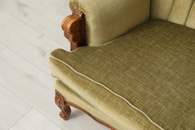 Photo of Soft sofa on light wooden floor, closeup. Used stuff