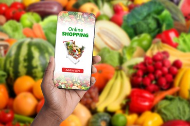Image of Food delivery. Man using mobile phone app to order grocery online, closeup